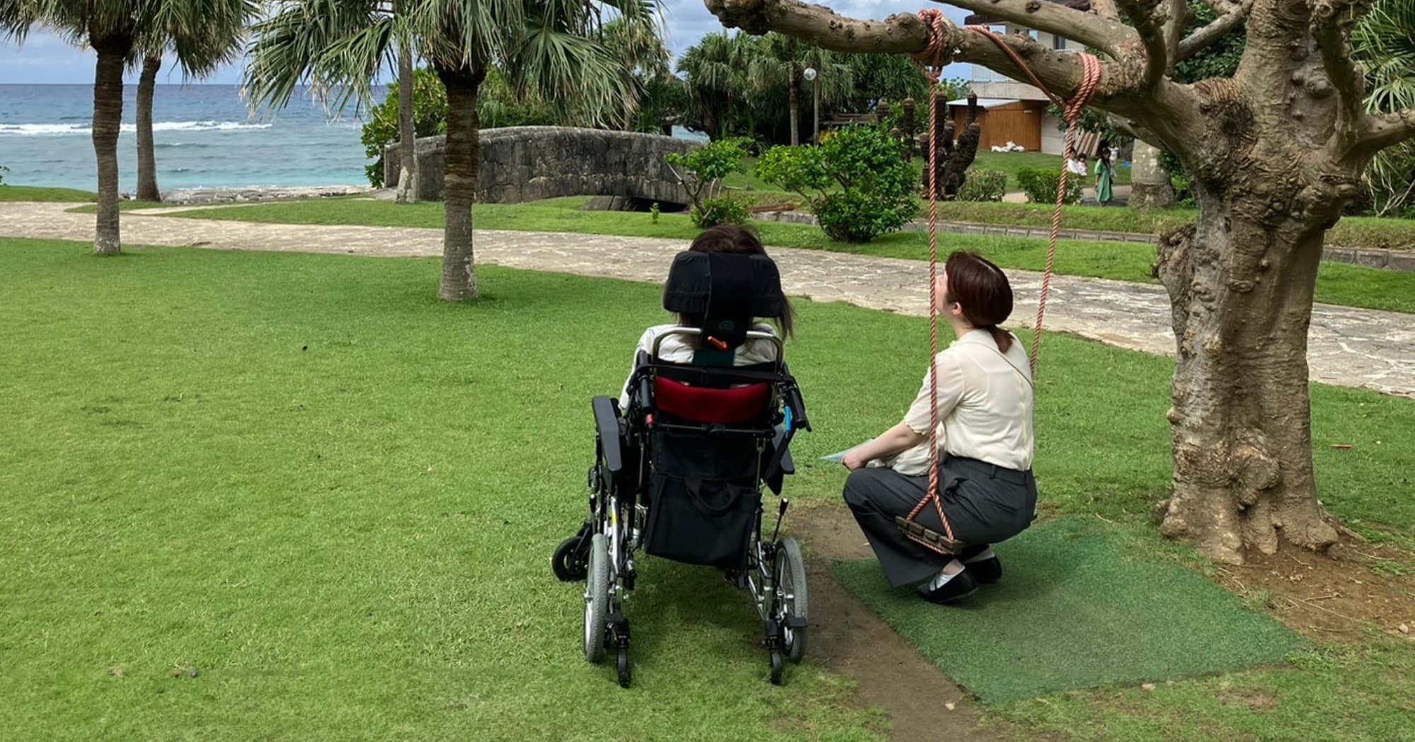 車椅子に座る女の人とブランコに座る女の人