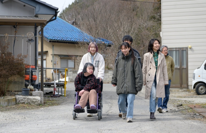 車椅子の方と6人が散歩している